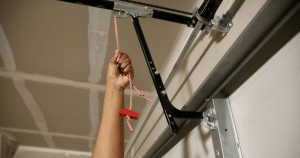 person checking garage door spring